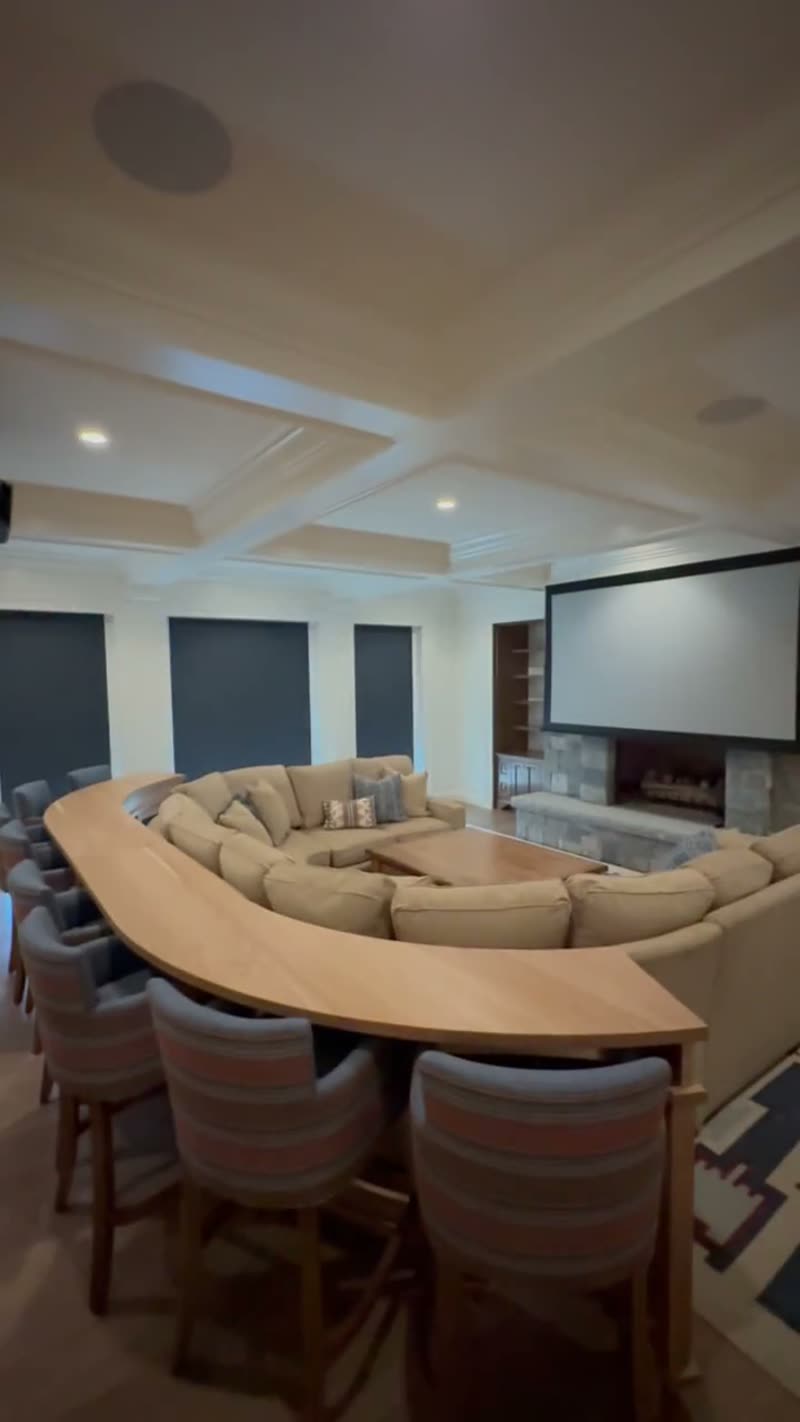 Drop-down projection screen deploying over the fireplace